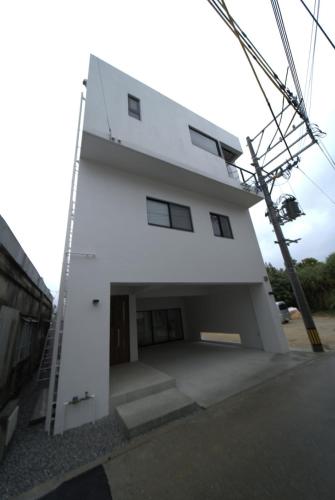a large white building with a large garage at LAGUNA OKINAWA Beachfront YAKA in Kin