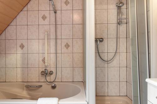 a bathroom with a shower and a bath tub at Ferienhaus Blumenstock in Steinsfeld