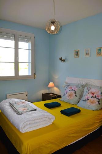 - une chambre dotée d'un grand lit avec des draps jaunes dans l'établissement Au Bord de L'Ô, à Saint Lo