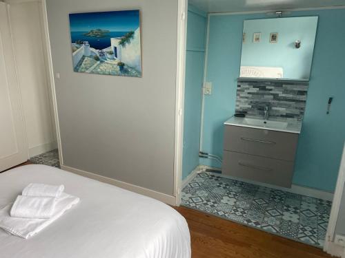 - une chambre avec un lit blanc et un lavabo dans l'établissement Au Bord de L'Ô, à Saint Lo