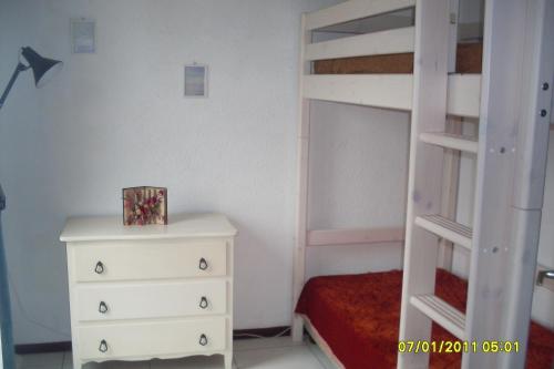 - une chambre avec des lits superposés, une commode et un lit dans l'établissement Appartement 4 personnes Seignosse Océan, à Seignosse