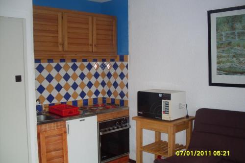 Il comprend une petite cuisine équipée d'un four micro-ondes et d'un comptoir. dans l'établissement Appartement 4 personnes Seignosse Océan, à Seignosse