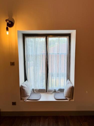 Cette chambre dispose d'une fenêtre avec des rideaux et des oreillers blancs. dans l'établissement Studio de l horloge, à Lyon