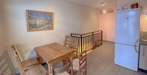 une cuisine avec une table et un réfrigérateur dans l'établissement Logement 7pers-15mn Piste-Exposé Sud-Cœur station, à Aillon-le-Jeune