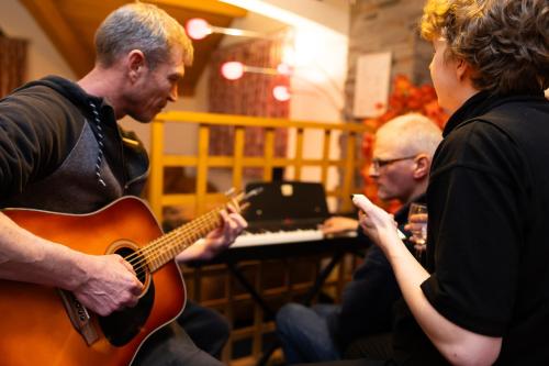 a group of people playing music with a guitar at Hotel l'Aigle in Valmeinier