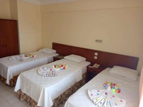 two beds in a hotel room with decorations on them at Nazar Hotel in Didim