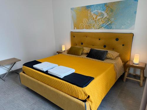a bedroom with a large yellow bed with two pillows at Dear Mary, B&B romantico vicino Lecce nel cuore del Salento in San Cesario di Lecce