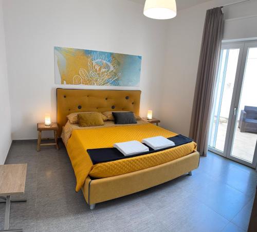 a bedroom with a large bed with a yellow blanket at Dear Mary, B&B romantico vicino Lecce nel cuore del Salento in San Cesario di Lecce