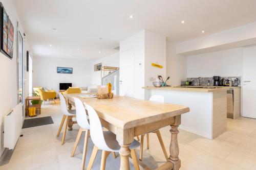 une cuisine et une salle à manger avec une table et des chaises en bois dans l'établissement Ti Penn ar Porz - Vue port, à Tréffiagat