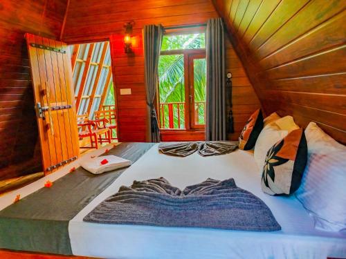 a large bed in a room with a window at Sigiriya Eco Tree House in Sigiriya