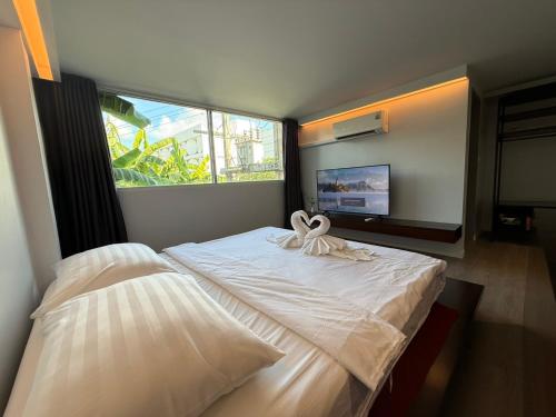 a bedroom with two beds and a large window at P168 Hostel Samui in Chaweng