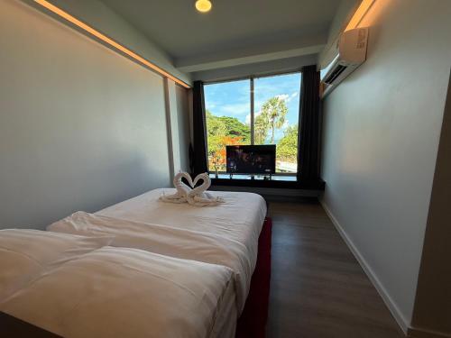 a room with a bed with a window and a tv at P168 Hostel Samui in Chaweng