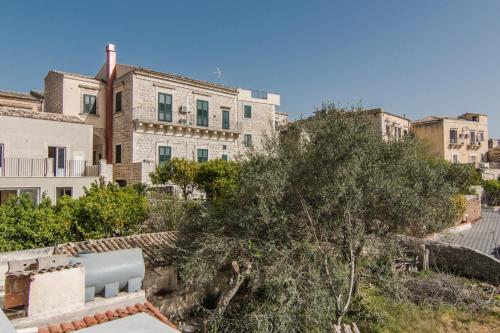 a view of a building with a tree and buildings at B&B Il Giardino Dei Mandarini in Modica