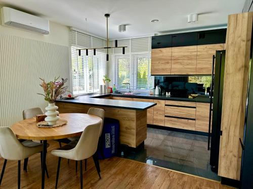 a kitchen with a table and chairs and a counter at Mużakowski Forest Retreat - rezydencja z basenem in Bronowice