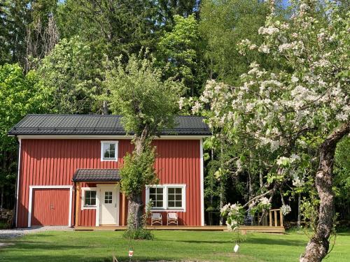 a red shed with a white door in a yard at Lodge in natuurreservaat in Glava
