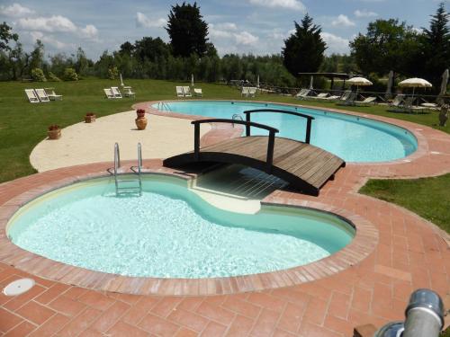a large swimming pool with a wooden deck around it at Fattoria di Colleoli in Colleoli