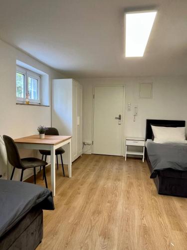 a room with a bed and a table and a bed and a desk at 005- Zentral & ruhig mit SmartTV in Fellbach
