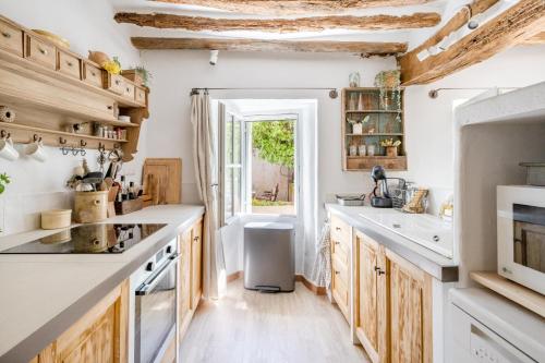 una cocina con encimeras blancas y armarios de madera en Chez Fanny, en Bédoin