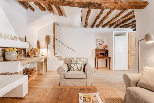 d'un salon avec des murs blancs et des poutres en bois. dans l'établissement Chez Fanny, à Bédoin