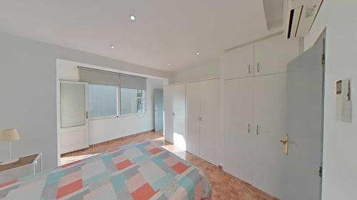 a white room with a bed and a window at Mar & Sol Pineda in Pineda de Mar