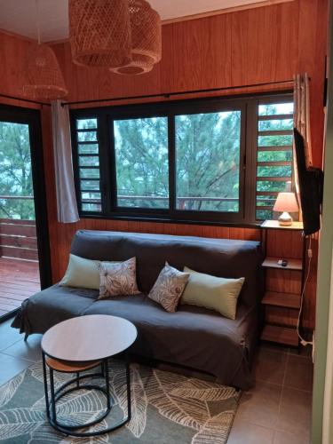 a living room with a couch and a table at Fare TANGARA in Arue