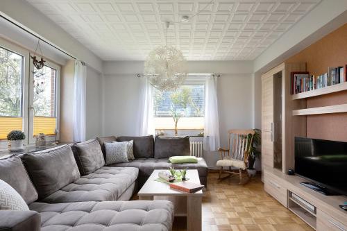 a living room with a couch and a tv at Gästehaus Tadenswarf in Tadenswarf