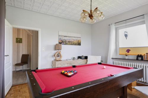 a room with a red pool table in it at Gästehaus Tadenswarf in Tadenswarf