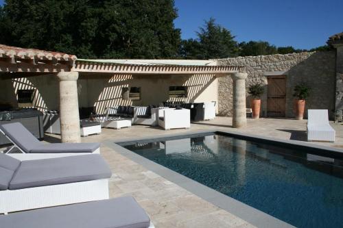 une piscine avec des chaises blanches et une terrasse dans l'établissement Gers Pool and Panorama, à La Romieu