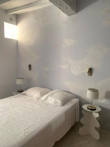 - une chambre blanche avec un lit et deux lampes dans l'établissement Gers Pool and Panorama, à La Romieu