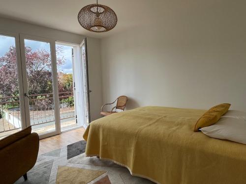 a bedroom with a bed and a large window at Les Trente Glorieuses in Épône