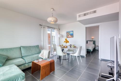 un salon avec un canapé vert et une table dans l'établissement Krystal Palace - Splendid Sea View - Happy Rentals, à Beausoleil