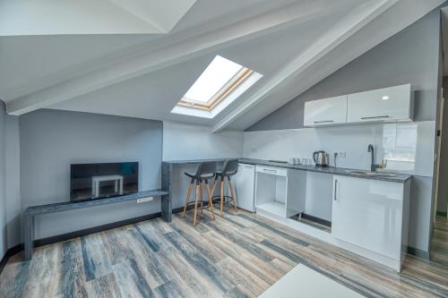 an attic kitchen with white cabinets and a skylight at Grisverde Suites in Istanbul
