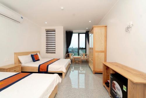 Una habitación de hotel con dos camas y una ventana. en TN Luxury Hotel, en Sầm Sơn