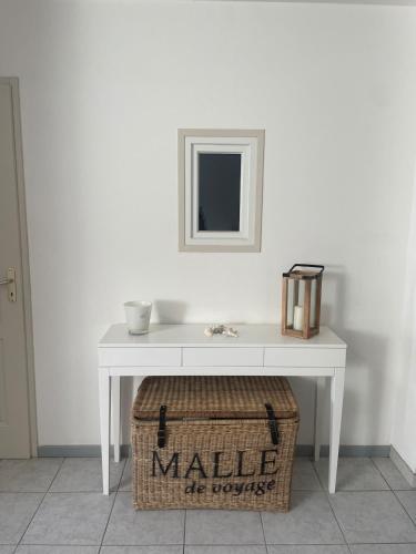 une table blanche avec un miroir et un panier en dessous dans l'établissement Capra Scorsa, Maison avec spa privatif face plage Lozari, Ile Rousse, à Belgodère