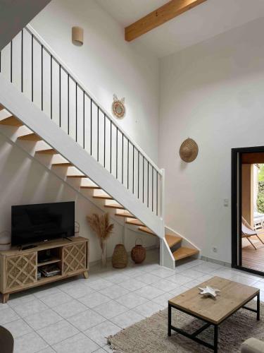 - un salon avec une télévision et un escalier dans l'établissement Capra Scorsa, Maison avec spa privatif face plage Lozari, Ile Rousse, à Belgodère