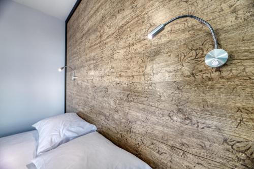 a bedroom with a wooden wall with a bed and a lamp at Grisverde Suites in Istanbul