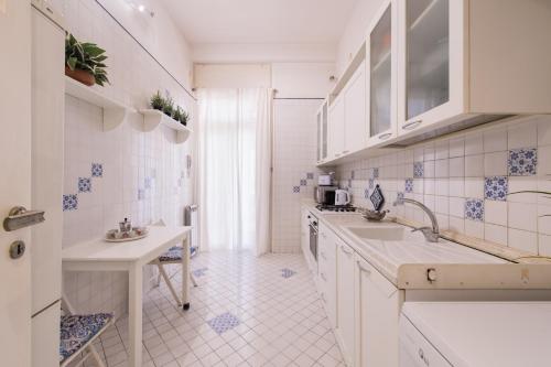 een keuken met witte kasten en blauwe en witte tegels bij Carità Grandi Residenze Napoli in Napels