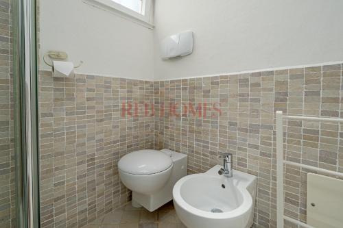 a bathroom with a toilet and a sink at La Caletta in Porto Rotondo