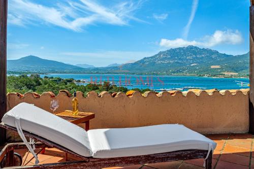 a white chair on a balcony with a view of the water at La Caletta in Porto Rotondo