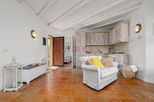 a living room with a white couch and a kitchen at La Caletta in Porto Rotondo