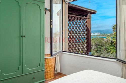 a room with a window with a bed and a view at La Caletta in Porto Rotondo