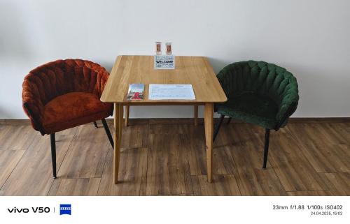 two chairs sitting next to a wooden table at Moderne Apartments mit Klima, perfekter Anbindung ins Zentrum und kostenlose Parkplätze! in Vienna