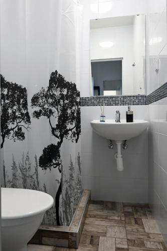 a bathroom with a sink and a toilet and a mirror at Penzión Šariš in Prešov