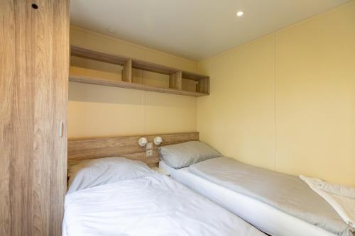 two beds in a bedroom with white sheets at Vranovská pláž - Holiday park in Vranov nad Dyjí