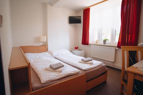 a bedroom with a bed with two pillows on it at Penzion PANORAMA Janovičky in Broumov