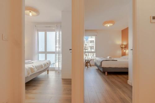 une chambre avec deux lits et une chambre avec une fenêtre dans l'établissement Cassiopee, spacieux et familiale 3 chambres, à Annecy