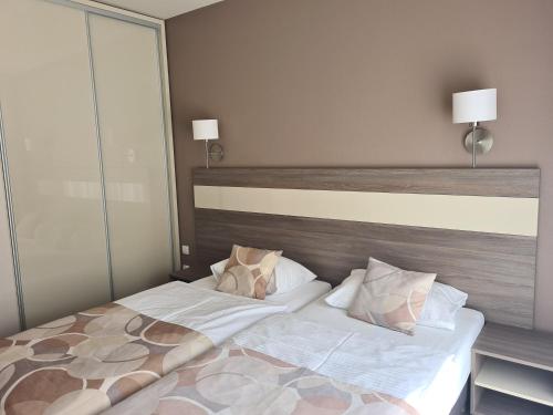 una camera da letto con un letto grande con lenzuola e cuscini bianchi di Apartamenty Czarna Góra Is 7 a Sienna