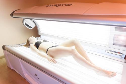 a woman in a bikini laying on a bed at Hotel Garden Experience in Città di Castello