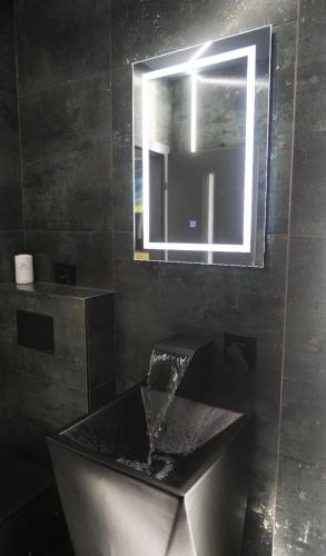 a bathroom with a sink and a mirror at Luna Apartments A in Suceava