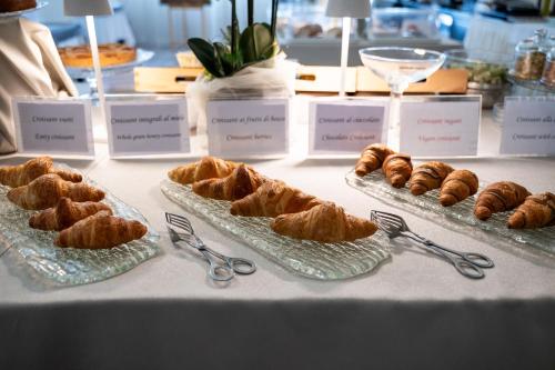 a table with plates of pastries and pairs of scissors at Hotel Garden Experience in Città di Castello